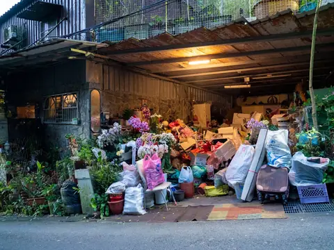 A large pile of household junk heaped in front of an open garage