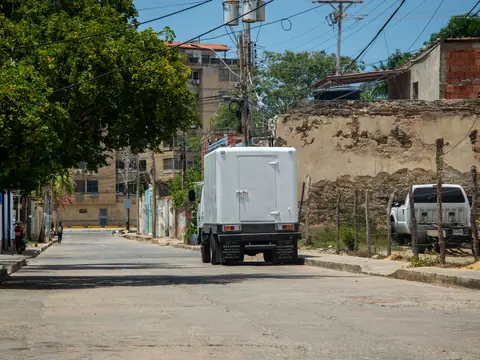 A plain white box truck parked on a sunny street