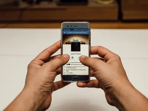 Two hands holding a smartphone open on a web page